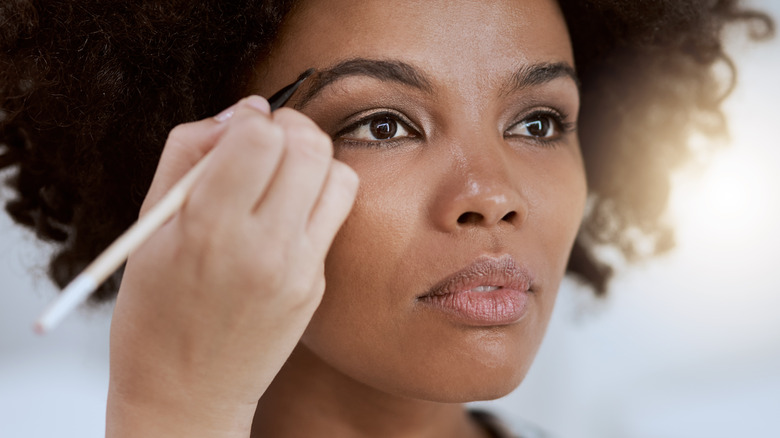 Woman filling in her eyebrows