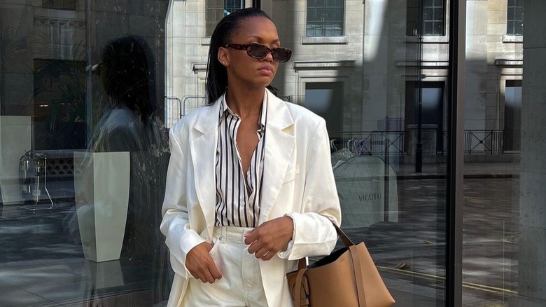 Influencer poses in a cream quiet luxury outfit