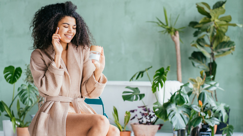 Woman in plant-filled bathroom