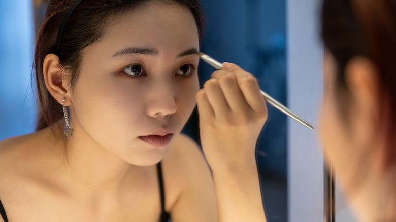 Woman doing eyebrow makeup