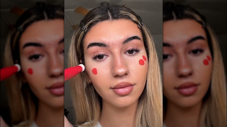 Woman applying red blush