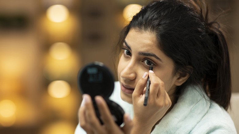 Woman applying eyeliner