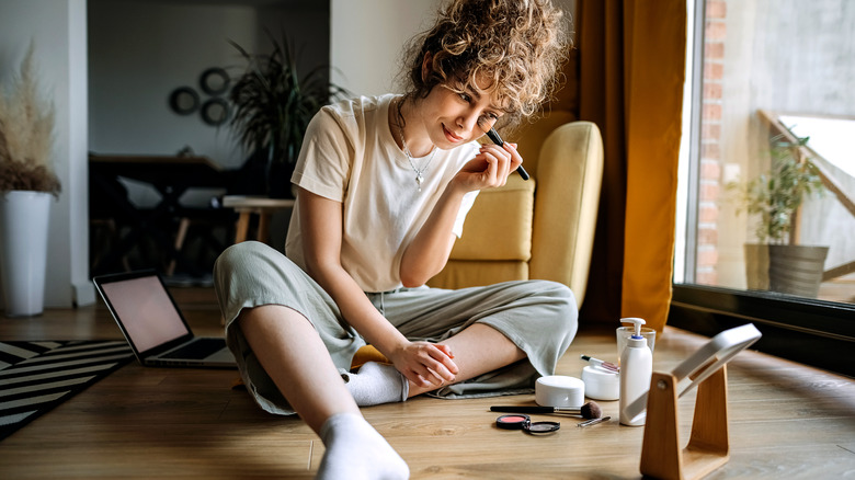 woman putting on makeup