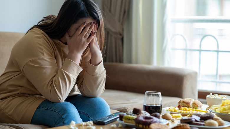 Woman looking sad next to food