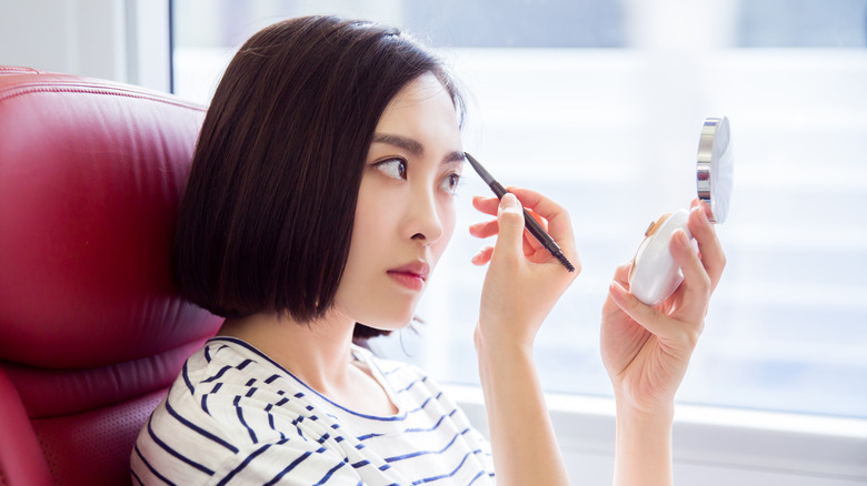 Woman filling in her eyebrows