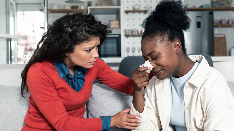 A woman comforting her friend who is crying 